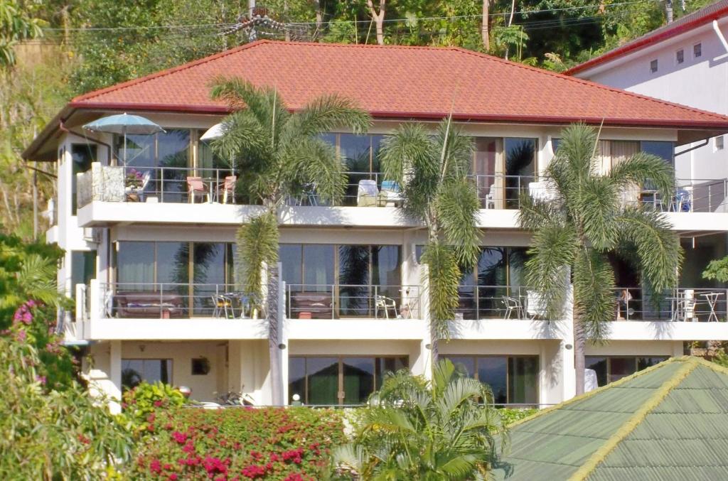 a building with palm trees in front of it at Mountain Seaview Luxury Apartments in Kata Beach