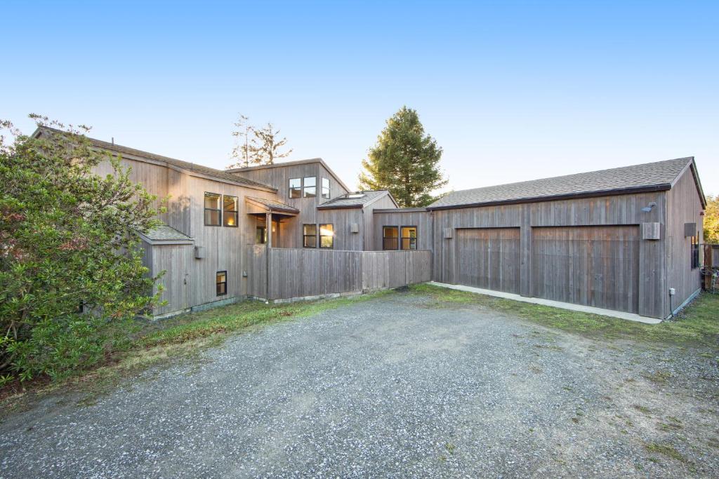 uma casa com uma cerca de madeira e uma garagem em Footloose em Sea Ranch