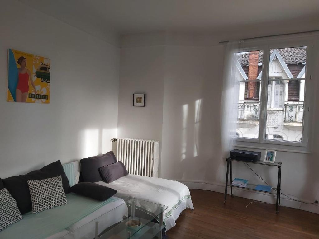 un salon avec un canapé et une fenêtre dans l'établissement Sun palace, à Vichy