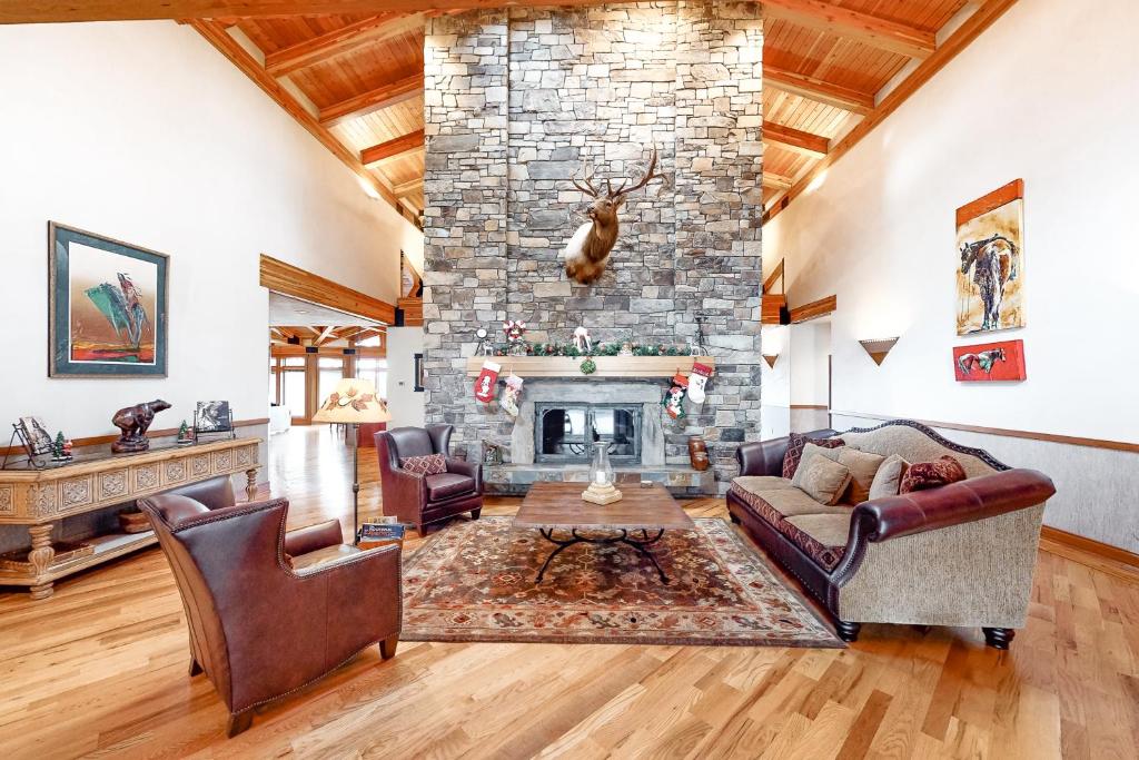 a living room with a stone fireplace with two couches at High Road Estate in Kalispell