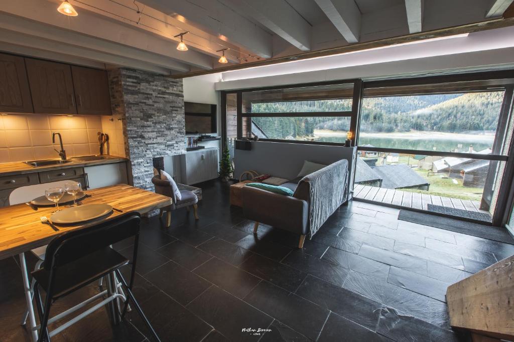 een keuken en een woonkamer met een tafel en stoelen bij Gîte Le Petit Arbizon in Campan