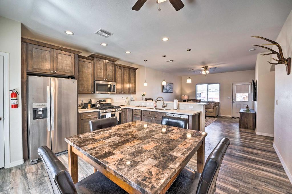 uma cozinha com uma mesa de madeira e uma cozinha com um frigorífico em Pet-Friendly Retreat - 1 Block to Colorado River! em Bullhead City