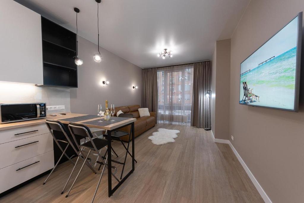 una cucina e un soggiorno con tavolo e TV di New modern apartments. metro Minskaya a Kiev