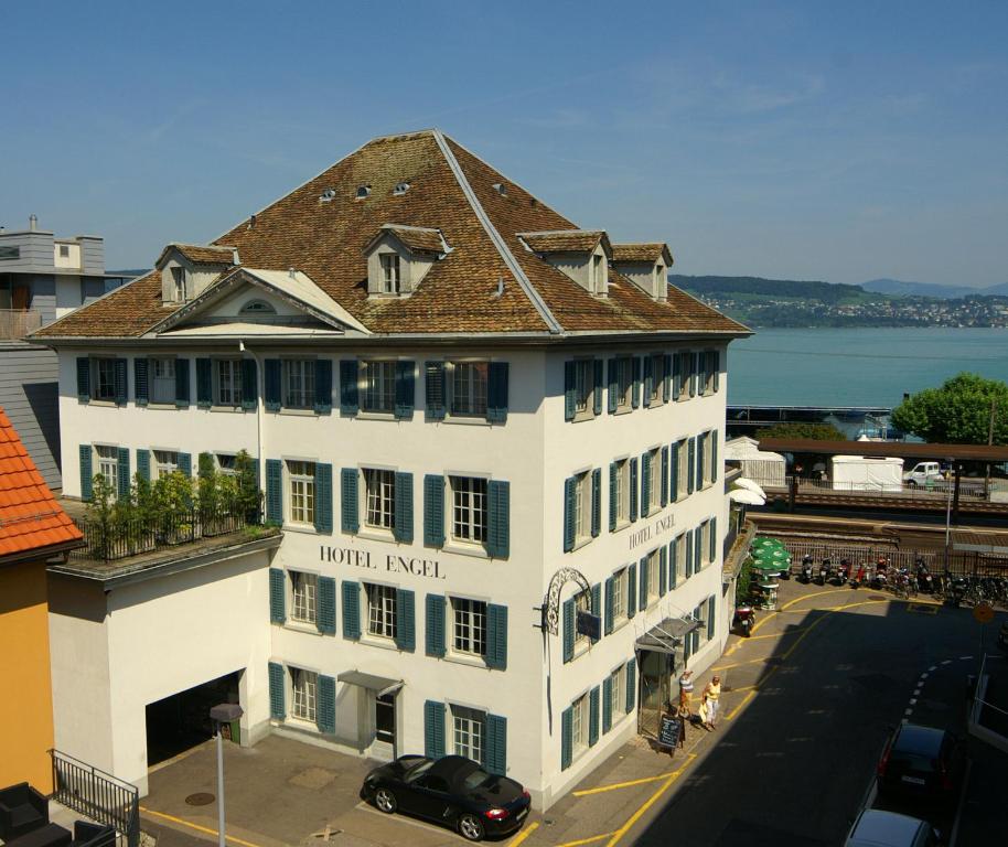 a large white building with a brown roof on a street at Hotel Engel am Bahnhof in Wädenswil