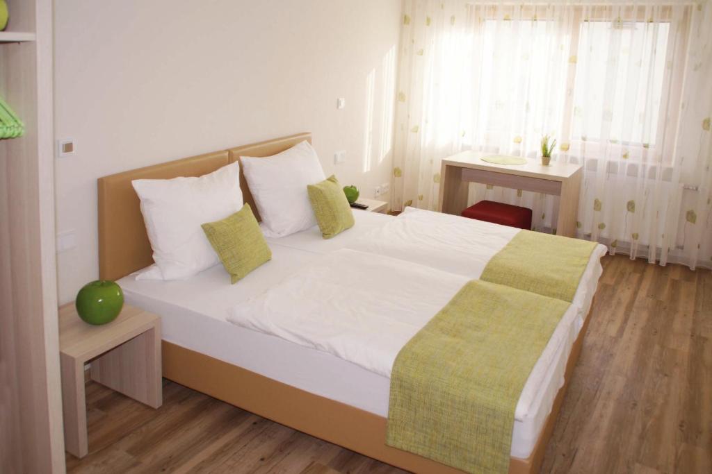 ein Schlafzimmer mit einem großen weißen Bett und einer grünen Decke in der Unterkunft Gasthaus Wollscheid in Trier