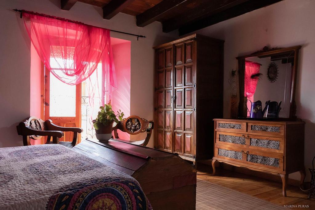 a bedroom with a bed and a dresser and a window at Hostal-Resturante La Moruga in Hortigüela