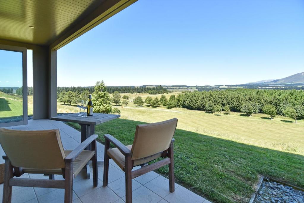 d'une terrasse avec une table et des chaises et une vue sur un champ. dans l'établissement High Country Villa 239 - Canterbury Terrace Downs, à Hororata