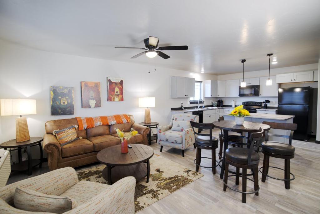 a living room with a couch and tables and a kitchen at Copper King Extended Stay Collection in Butte