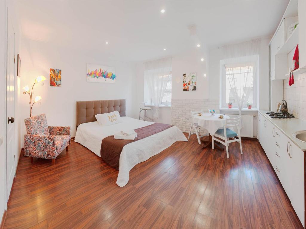 ein Schlafzimmer mit einem Bett und einem Tisch sowie eine Küche in der Unterkunft Apartment Ruska 12 in Lwiw