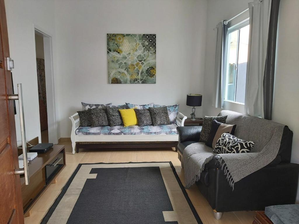 a living room with a couch and a window at Casa Arraial do Cabo in Arraial do Cabo