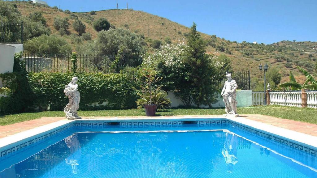 duas estátuas estão ao lado de uma piscina em Villa Joaquin - Casitas Select em Nerja