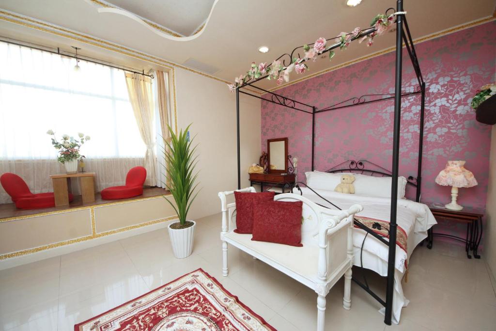 a bedroom with a canopy bed and a white chair at Avica Homestay in Wujie