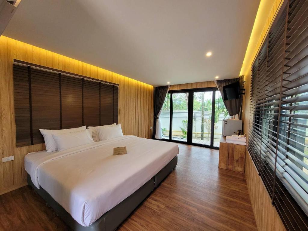 1 dormitorio con cama grande y ventana grande en Sunnyvale Ranong 2, en Ranong