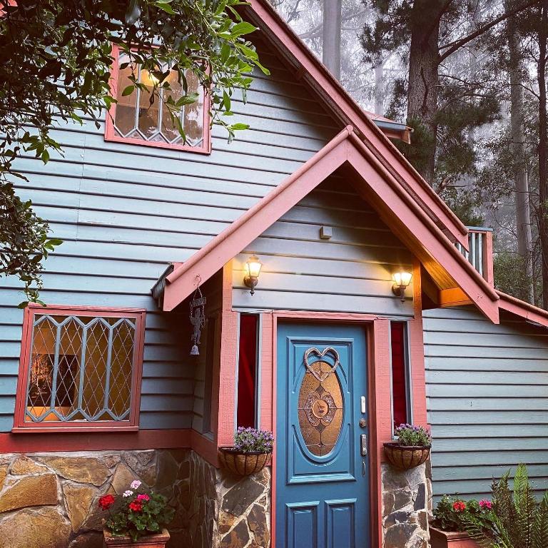 a red and blue house with a blue door at Wild Orchid Olinda Private Luxury Cottage in Olinda