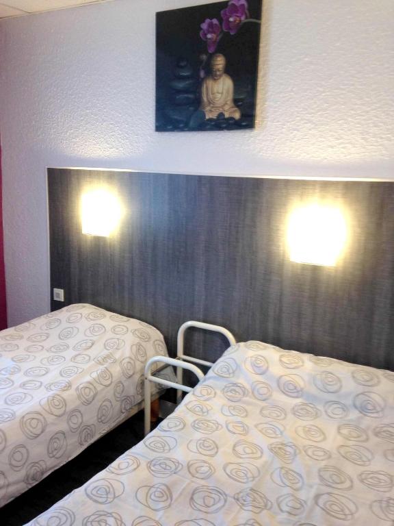 a room with two beds and a picture on the wall at Appartement de 2 chambres avec wifi a Neris les Bains in Néris-les-Bains