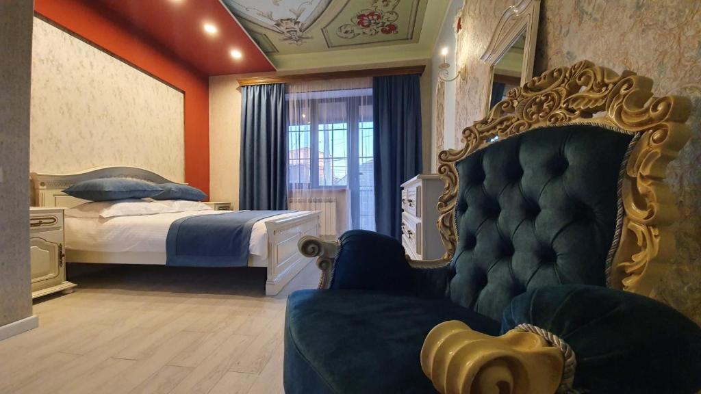 a bedroom with a bed and a couch and a chair at JINJOTEL Gyumri in Gyumri