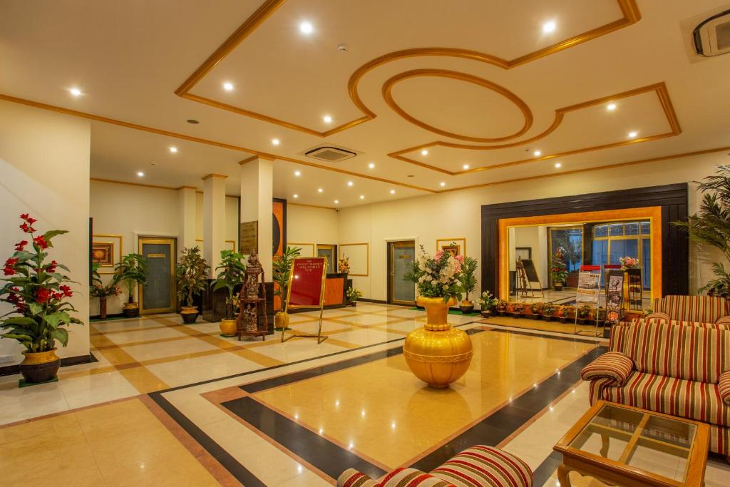 eine große Lobby mit einer großen Vase auf dem Boden in der Unterkunft The Grand Regency in Rajkot