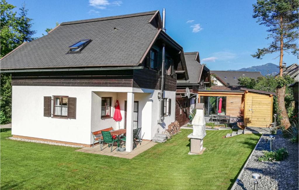 una casa blanca con techo negro y patio en Ferienhaus In Feistritz en Ludmannsdorf