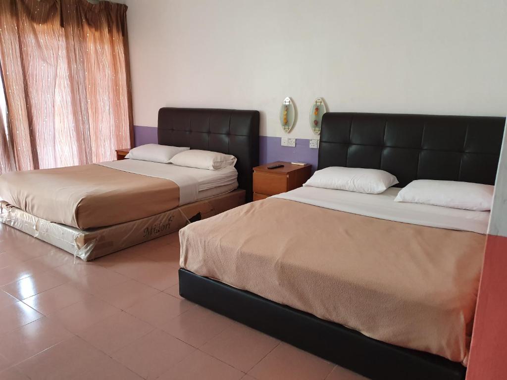 two beds in a room with two bedsskirts at Ten Inn in Kuala Terengganu