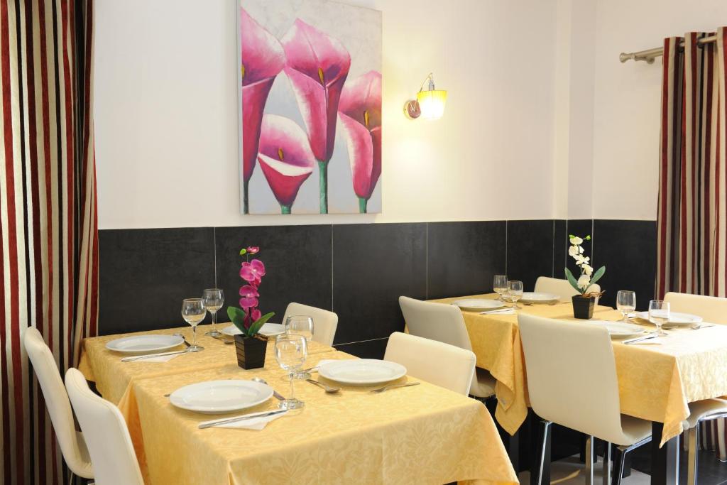 uma sala de jantar com mesas e cadeiras e um quadro em Inn Luanda em Luanda