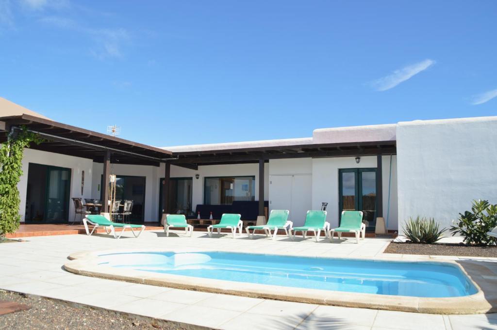ラ・オリーバにあるVilla spacieuse et lumineuse avec piscine Chaufféeのパティオ(椅子付)、スイミングプール