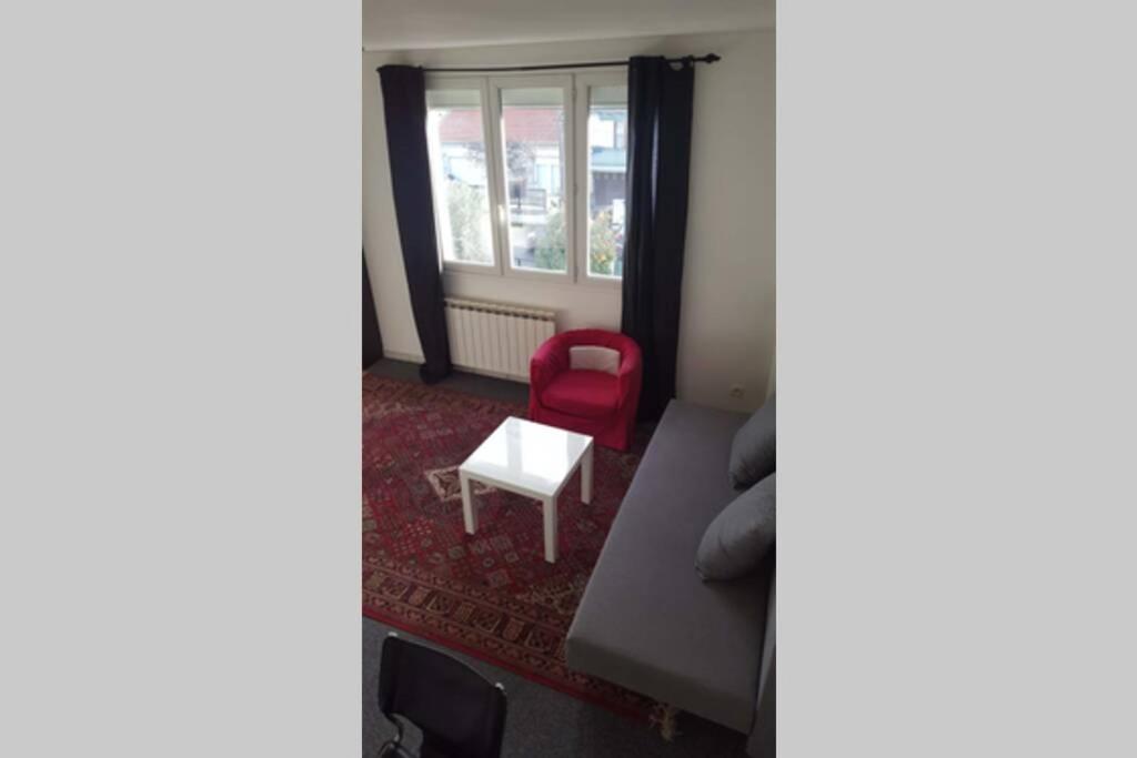 a living room with a couch and a red chair at Duplex 1 station tramway aéroport Paris-Orly in Athis-Mons