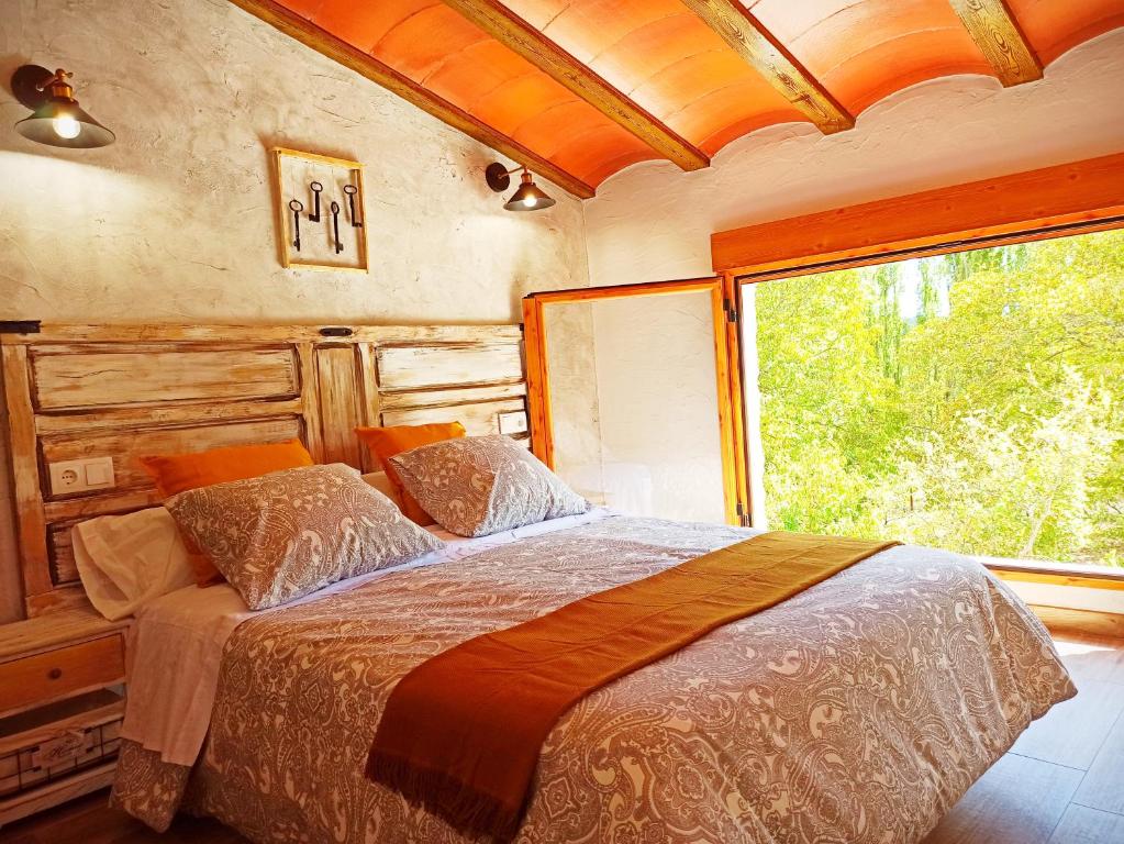 a bedroom with a bed and a large window at Cortijo Ramón petra ll in Nerpio