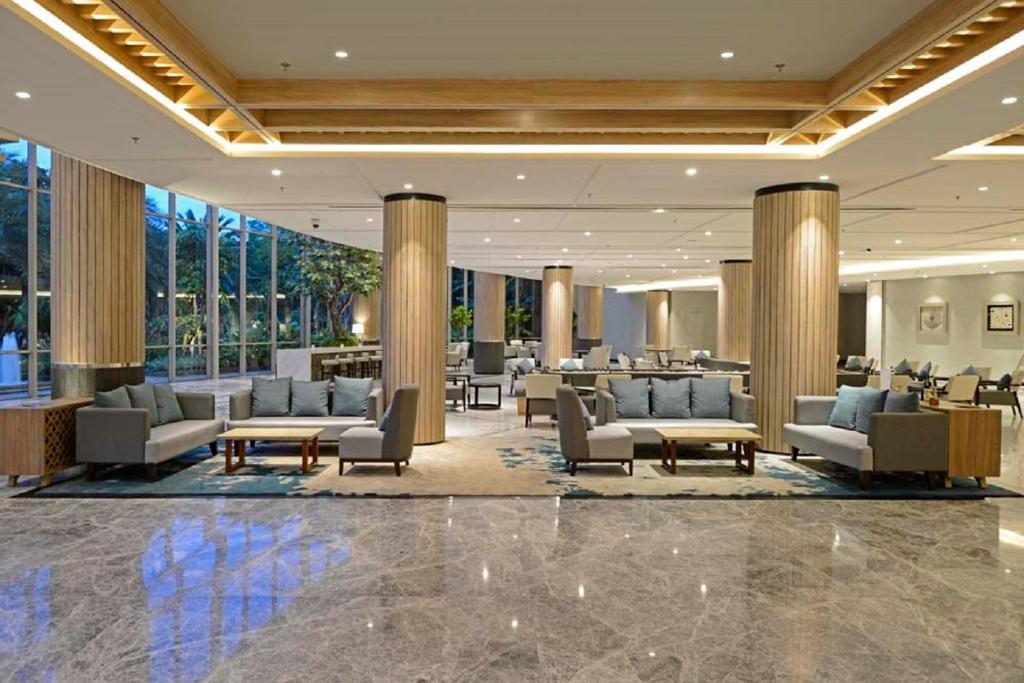 a lobby of a hotel with couches and tables at Discovery Ancol in Jakarta