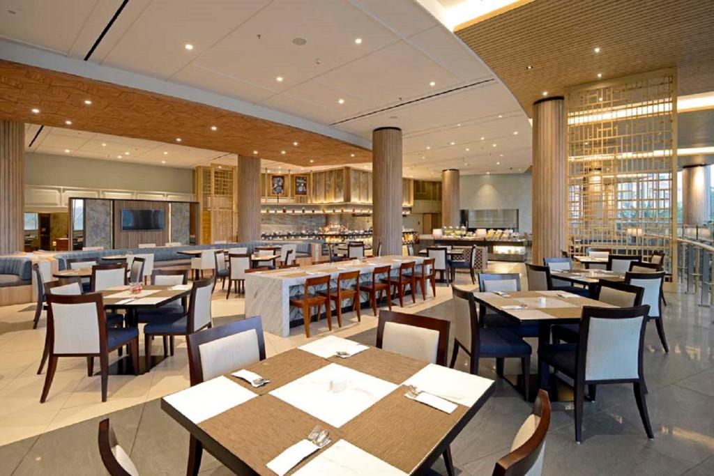 a restaurant with tables and chairs and a bar at Discovery Ancol in Jakarta