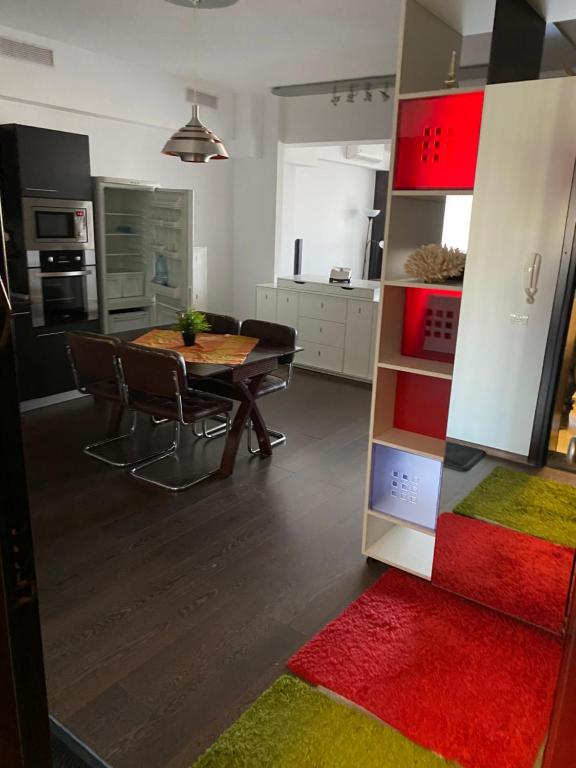 uma sala de estar com uma mesa e uma cozinha em GIS North House em Bucareste