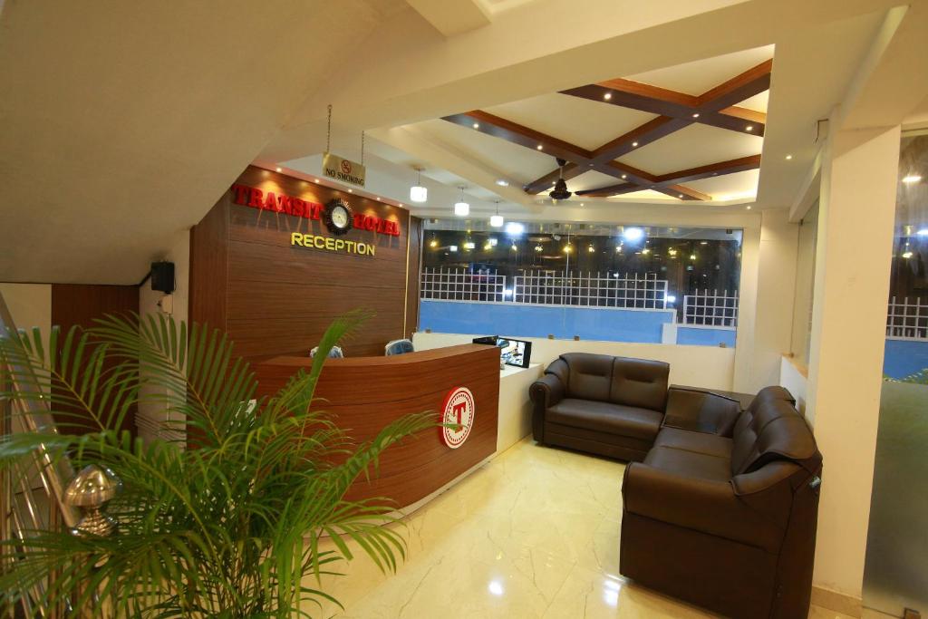a salon with a waiting room with a couch and a bar at Gateway Airport Hotel in Kannur