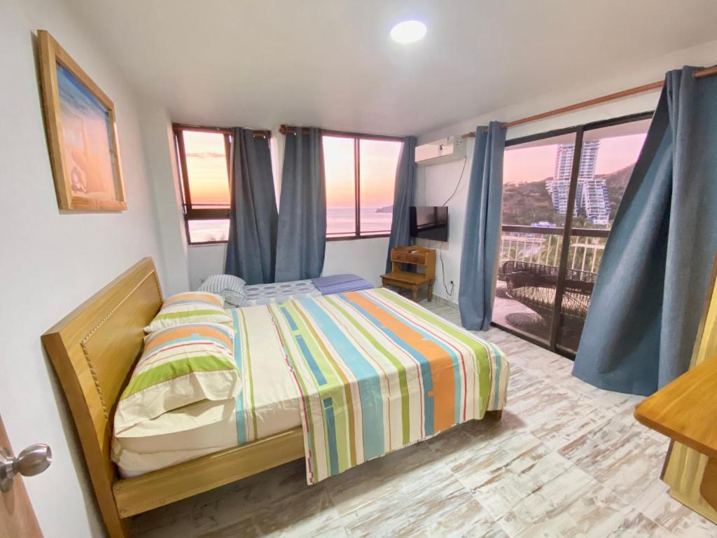 1 dormitorio con 1 cama y balcón en Caribbean Venture Apto 803 - Rodadero, Santa Marta, en Santa Marta