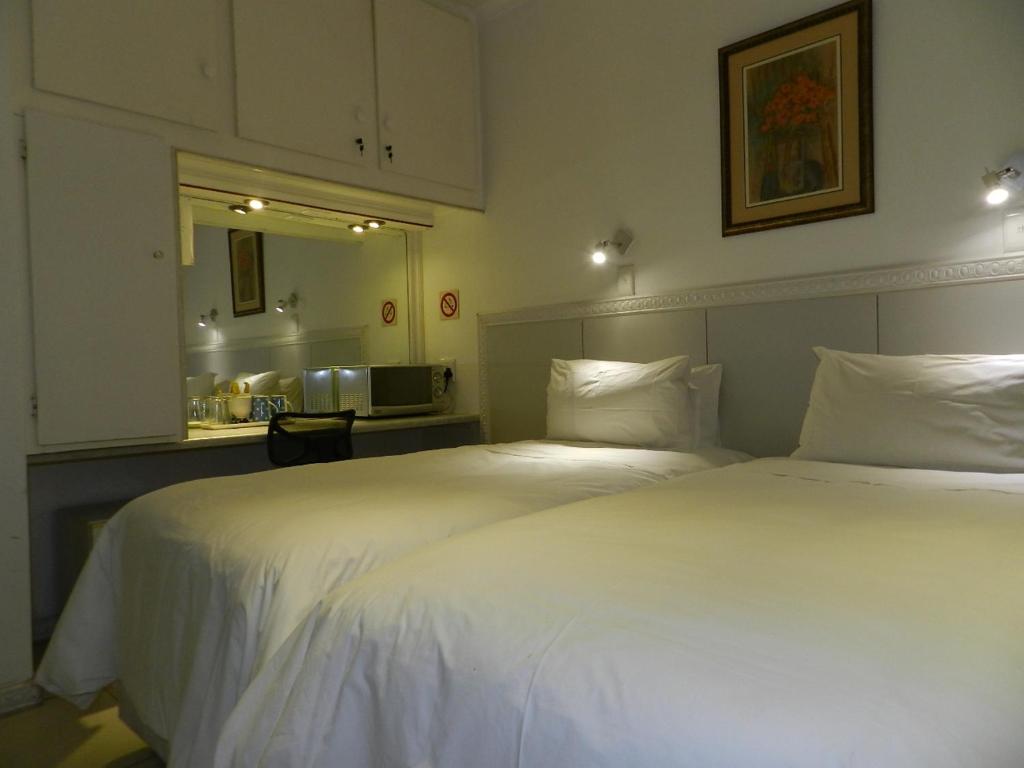 une chambre d'hôtel avec deux lits et une cuisine dans l'établissement Sleepers Villa Guesthouse, à Polokwane