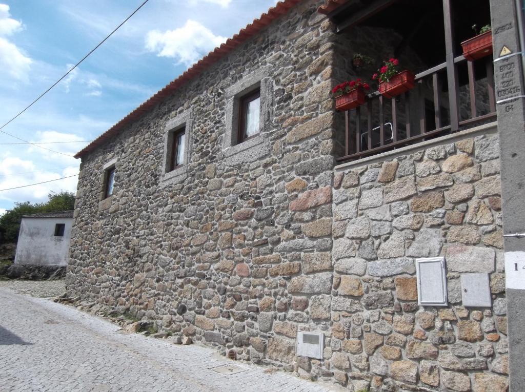 un edificio de piedra con una ventana en una calle en Casa do Pelourinho, en Rebordainhos