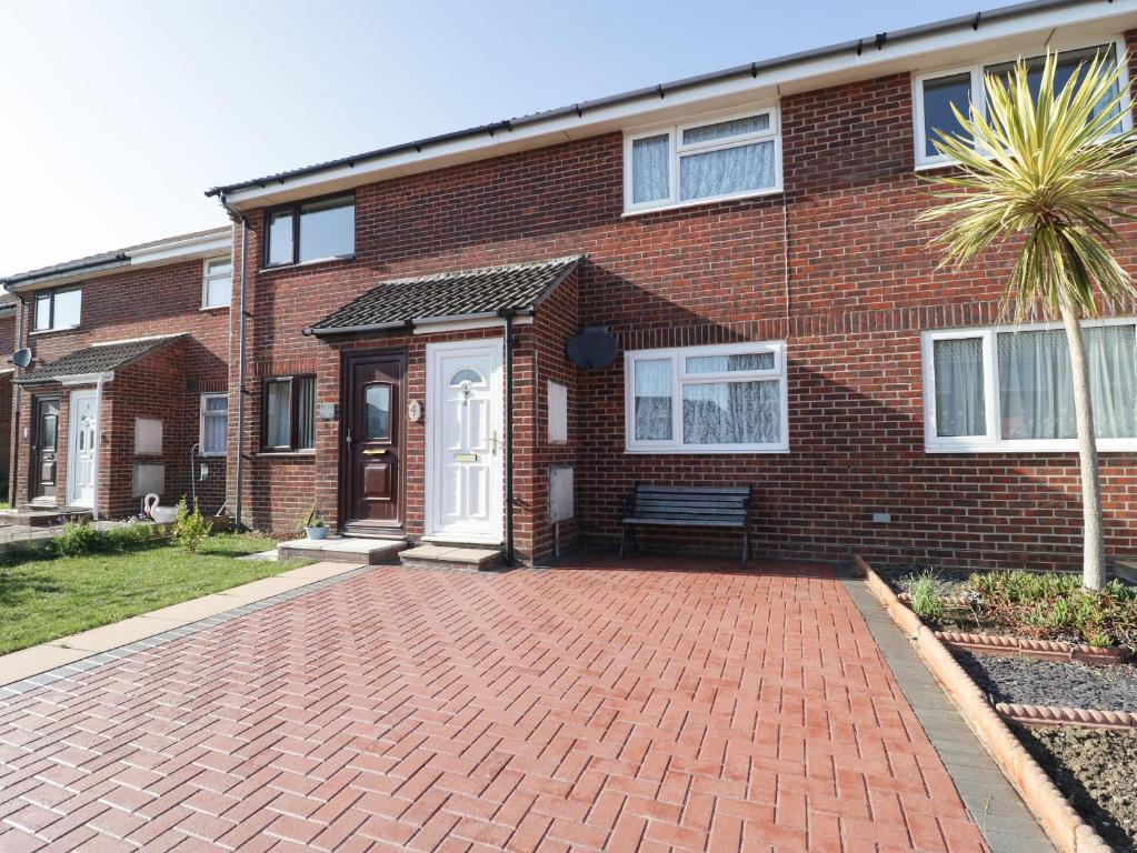 a brick house with a brick driveway in front of it at Jay Cottage in Weymouth