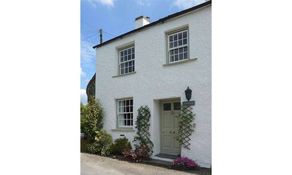 a white house with a white door and windows at Croft End Cottage in Sawrey
