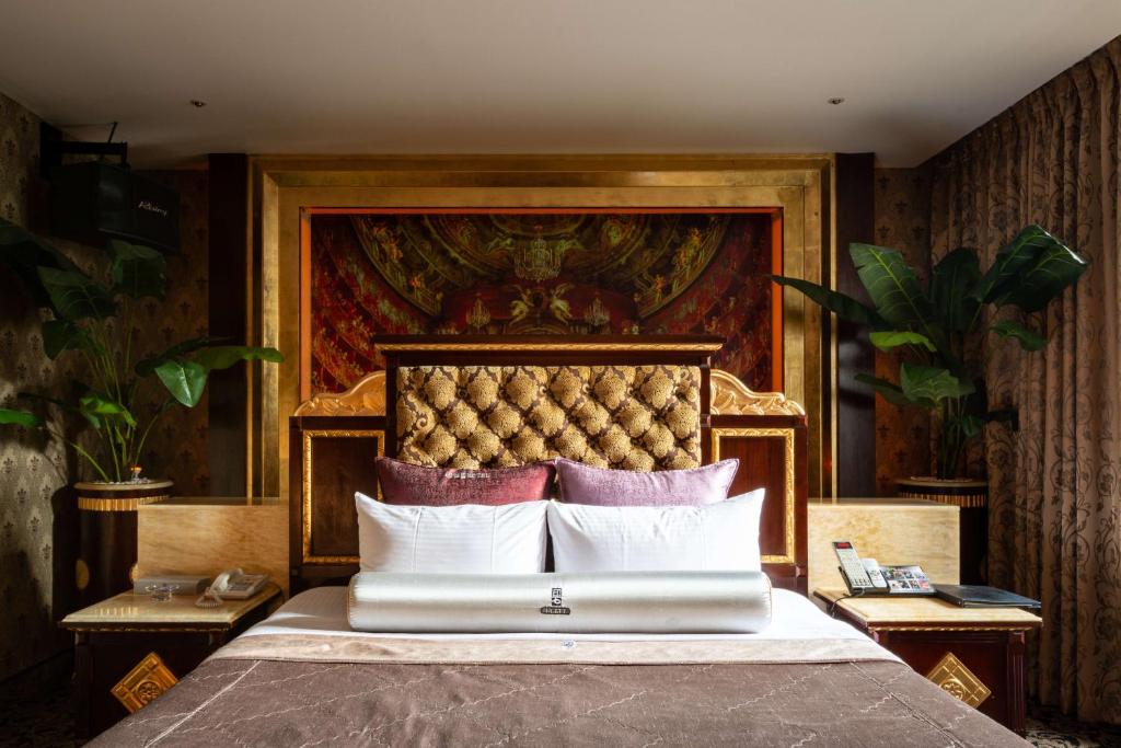 台北的住宿－印石時尚旅館，卧室配有一张大床,墙上挂有绘画作品