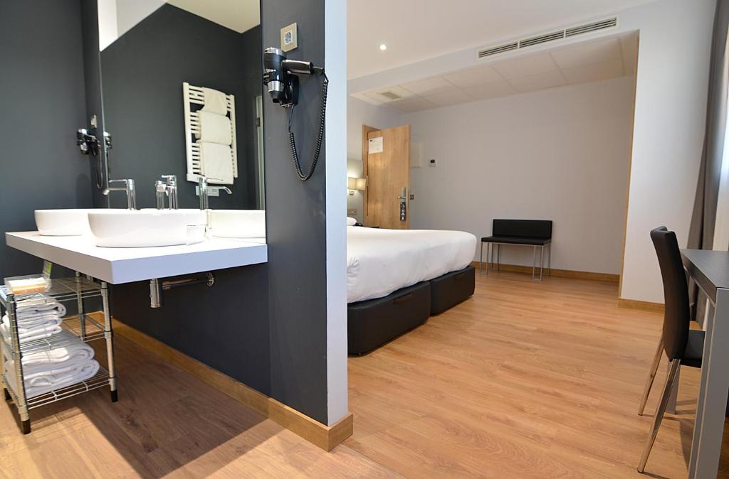 Habitación con baño con cama y lavabo. en UVE Alcobendas, en Alcobendas