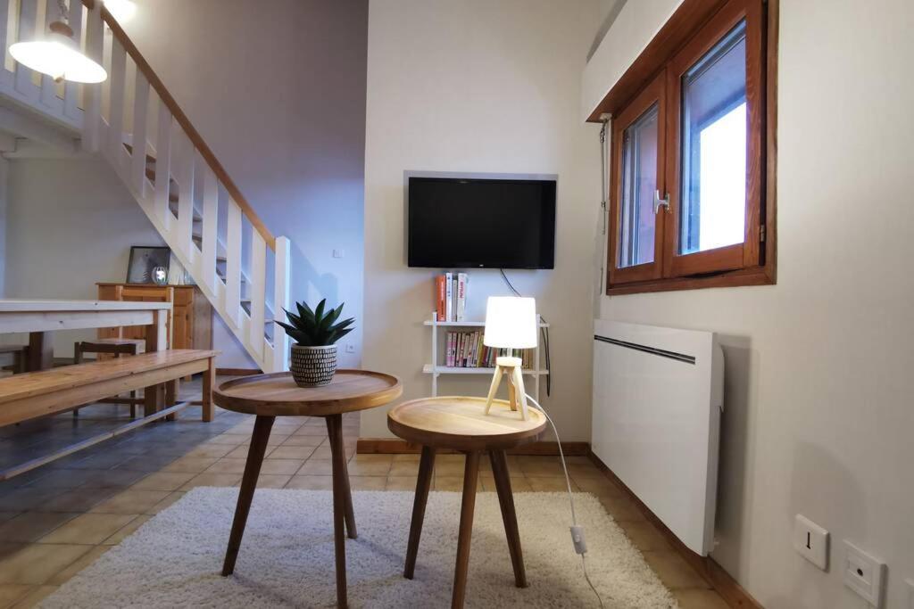 a living room with two tables and a tv at Ravissant appart proche suisse et pistes de ski familiales in Les Fourgs