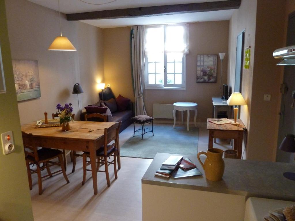 a kitchen and living room with a table and a dining room at L'Oustal du Sentier in Mur-de-Barrez
