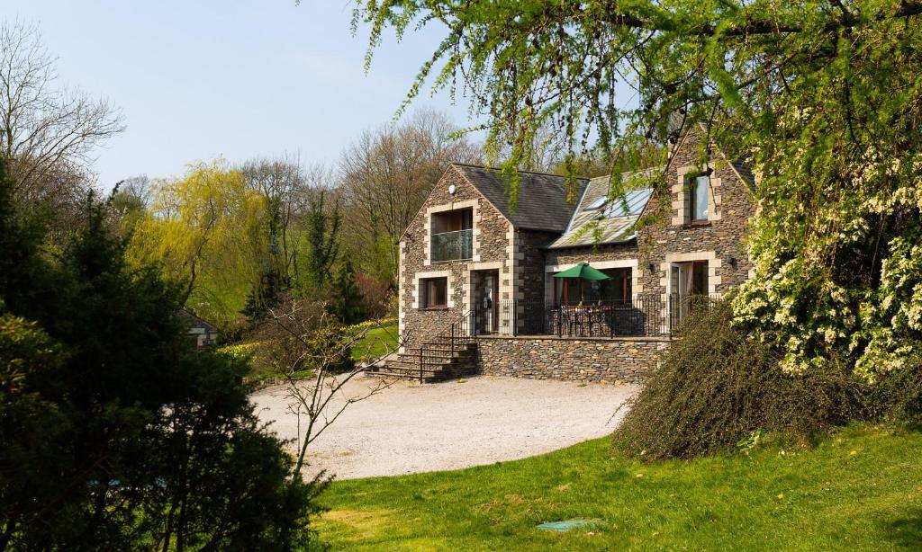 a large brick house with a green roof at Highbeck in Underbarrow