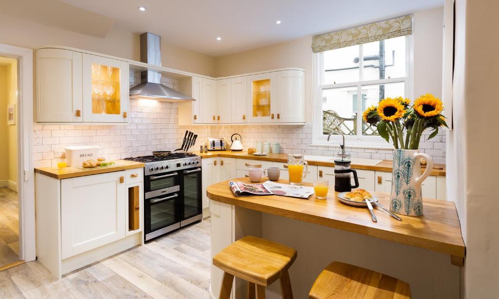 kuchnia z białymi szafkami i drewnianym blatem w obiekcie Brandelhow House w mieście Keswick