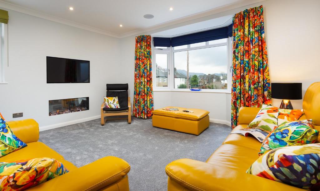 un soggiorno con mobili gialli e camino di Fell View a Keswick
