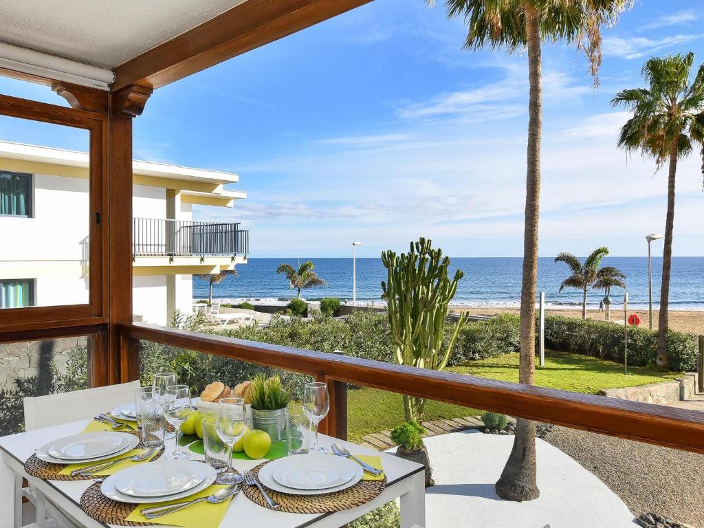 a dining table with a view of the beach at San Agustin Beach Apartments in San Agustin