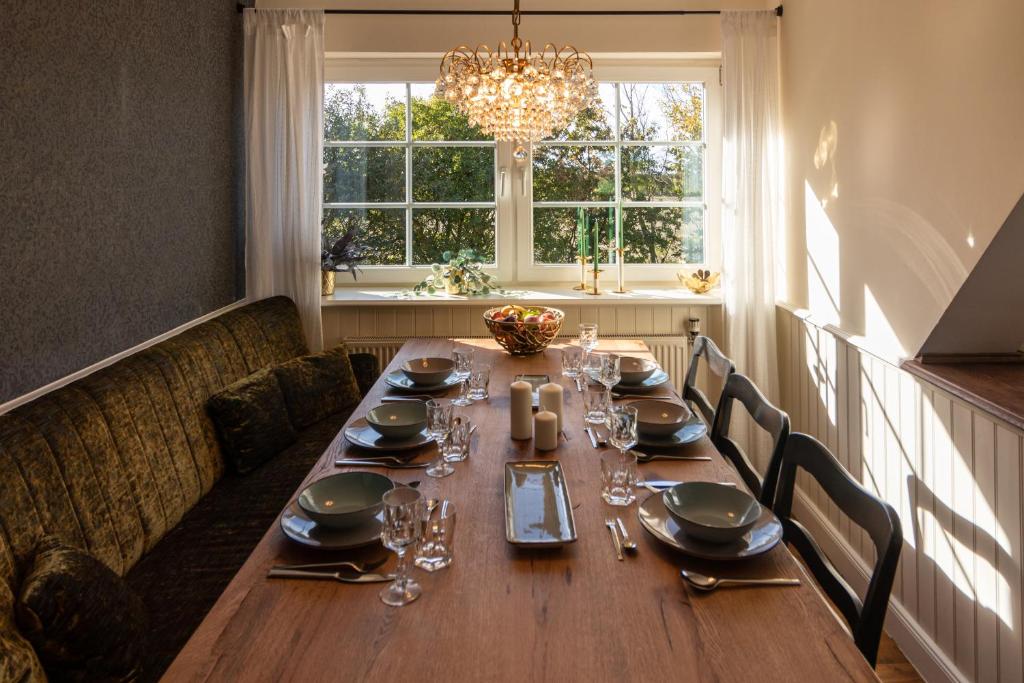 einen Esstisch mit Stühlen und einem Kronleuchter in der Unterkunft Henkieker - ländliche Ferienwohnung mit Stil in Fehmarn