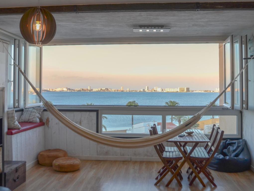a hammock in a room with a view of the ocean at Impresionantes Vistas al Mar Menor in Playa Honda