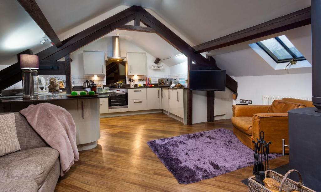 a living room with a couch and a kitchen at Hayloft in Windermere