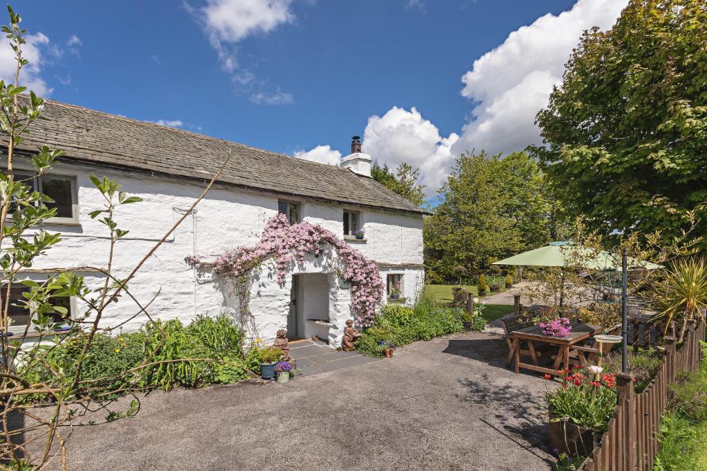 Ce cottage blanc dispose d'un jardin. dans l'établissement Smithy Cottage At Lindeth, à Windermere