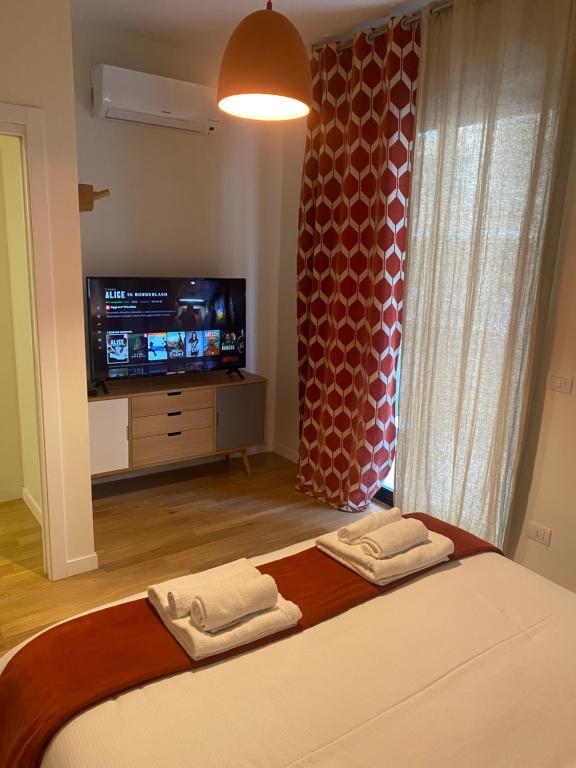 1 dormitorio con 1 cama, TV y 2 toallas en Futura Exclusive Suite 1, en Bari