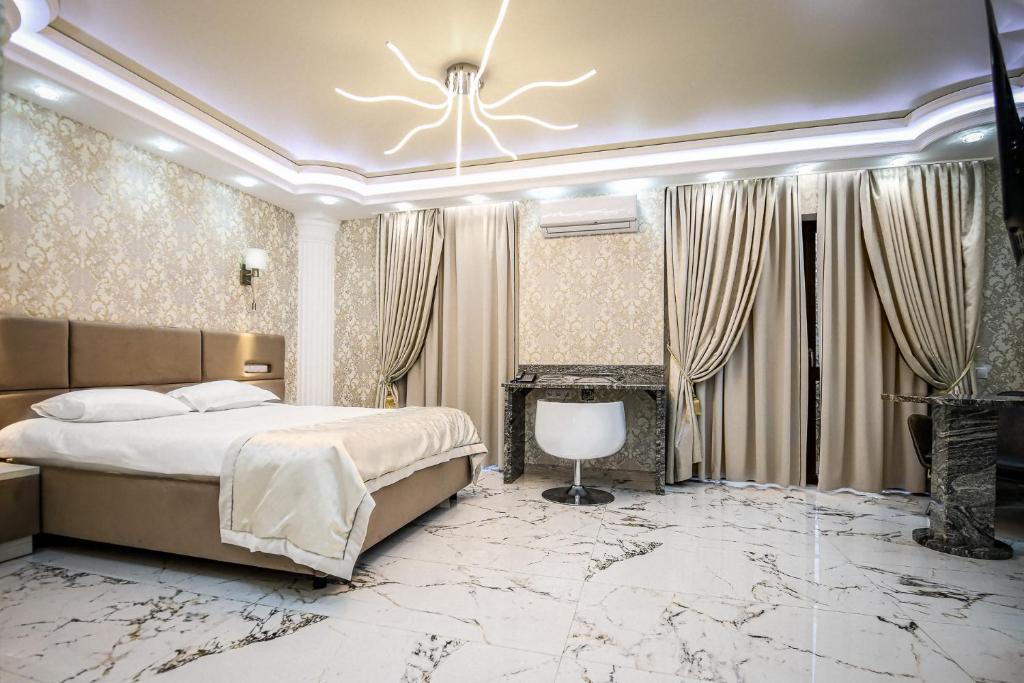 a bedroom with a king sized bed and marble floors at Prestige apart-hotel in Chişinău